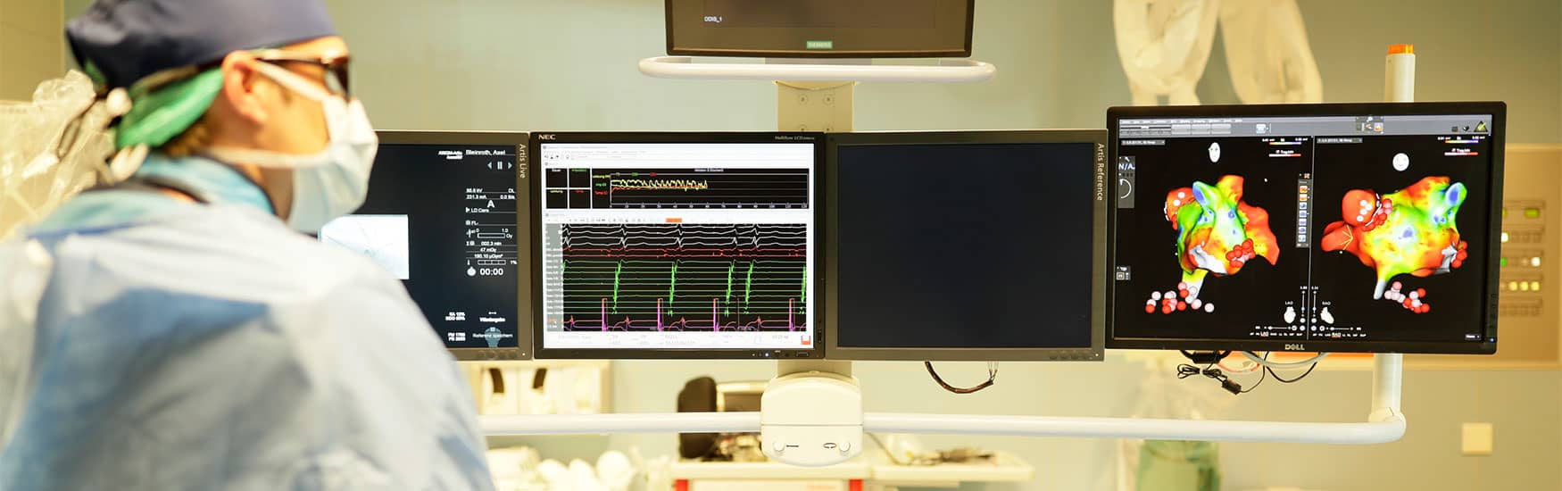Kardiologe im Herzkatheterlabor blickt auf Monitore