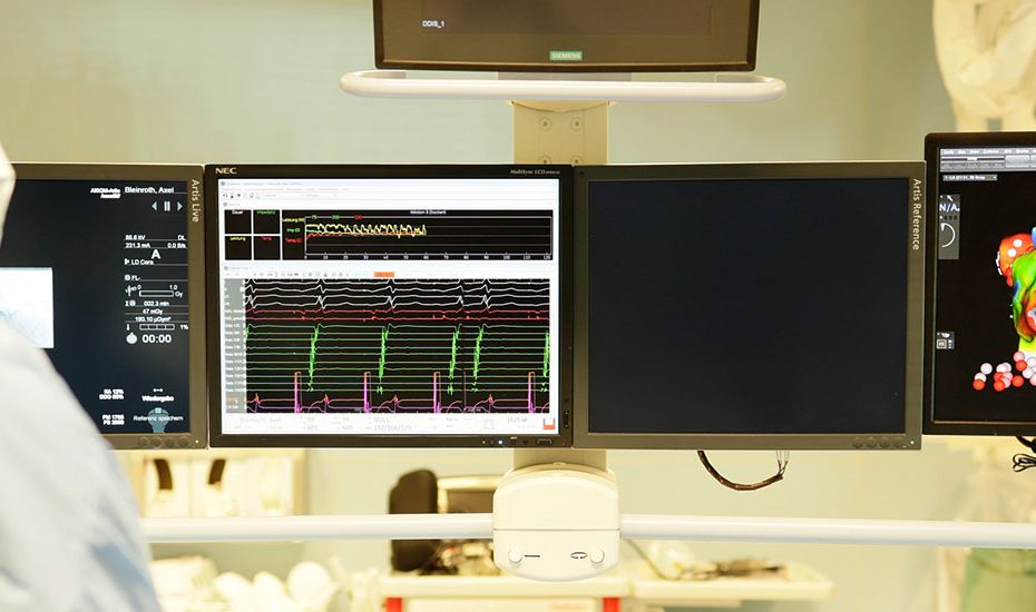 Kardiologe im Herzkatheterlabor mit Blick auf die Monitore